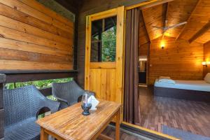 a wooden cabin with a table and chairs and a bed at Marron sea view resoort in Patnem