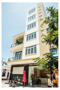 a tall building with a red umbrella in front of it at H Hotel in Quy Nhon