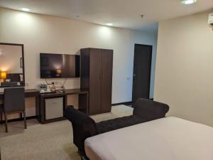 una stanza con un letto, una scrivania e una televisione di The View Hotel a Segamat