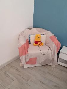 un ours en peluche Winnie l'ourson assis sur un lit dans l'établissement Au doux rêve, à Puyfebert