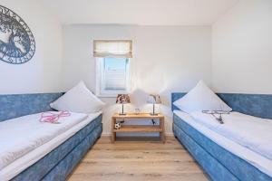 2 Betten in einem Zimmer mit einem Tisch in der Unterkunft Ferienwohnung Wiking-Koje 8 Schleswig in Schleswig