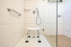 eine Dusche mit einem weißen Stuhl im Bad in der Unterkunft Ferienwohnung Wiking-Koje 8 Schleswig in Schleswig + 33 Fotos