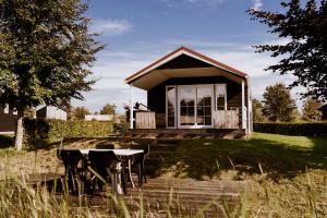 a small house with a table in front of it at Vakantiepark Eigen Wijze in Bant