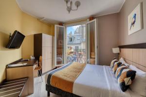 une chambre d'hôtel avec un lit et un balcon dans l'établissement Hotel Phenix Paris, à Paris