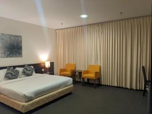 una camera d'albergo con un letto, un tavolo e delle sedie di The View Hotel a Segamat