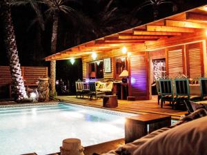 a swimming pool in front of a house at night at Diar Abou Habibi in Tozeur