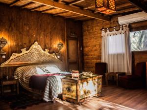 a bedroom with a large bed and a table at Diar Abou Habibi in Tozeur +7 photos