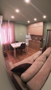 ein großes Sofa im Wohnzimmer mit einem Tisch in der Unterkunft Perla Apartment in Tirana