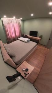 ein Schlafzimmer mit einem Bett und einem Schreibtisch mit einem Computer in der Unterkunft Perla Apartment in Tirana