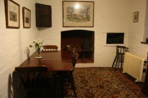 a dining room with a table and a fireplace at Brickendon in Longford
