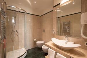 a bathroom with a sink and a shower and a toilet at Hotel Laurentia in Rome