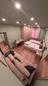 ein großes Sofa im Wohnzimmer mit einem Bett in der Unterkunft Perla Apartment in Tirana + 11 Fotos