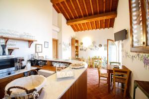 a large kitchen with wooden ceilings and a dining room at Gatto Bianco Tizzauli in Montespertoli