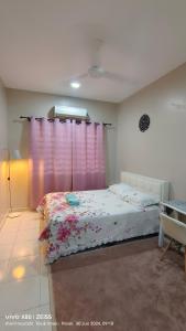 a bedroom with a bed with a pink curtain at Zulfa Homestay Teluk Intan in Teluk Intan +9 photos