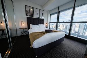 a hotel room with a large bed and large windows at Infinity Tower Brisbane City in Brisbane