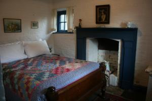um quarto com uma cama e uma lareira em Brickendon em Longford