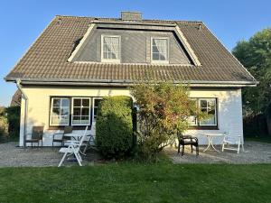 a house with chairs and tables in front of it at Nordsee Huus in Friedrichskoog-Spitz