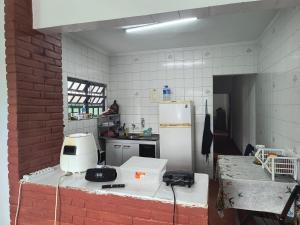 a kitchen with a white appliance on top of a counter at Casa de veraneio in Solemar +2 photos
