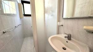 a white bathroom with a sink and a mirror at M328 - Marcelli, bilocale con vista mare in Marcelli