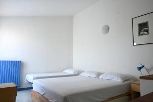 two beds sitting next to each other in a room at M328 - Marcelli, bilocale con vista mare in Marcelli