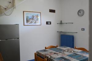 a kitchen with a table and a refrigerator at M328 - Marcelli, bilocale con vista mare in Marcelli +11 photos