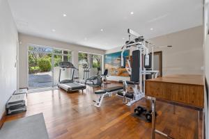 a room with a gym with exercise equipment in it at The Cape Bali Luxury Villa with Ocean Views in Camps Bay in Cape Town