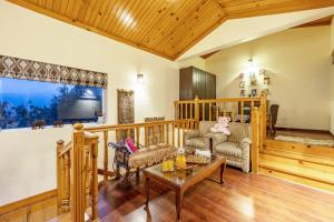 a living room with a couch and a table at Alaya Stays 2 BHK with Garden & Balcony - Villa Harmony in Bhowāli