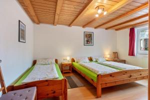 two beds in a room with wooden ceilings at Ferienwohnung Schwalbennest in Höchenschwand
