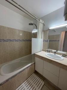 a bathroom with a sink and a bath tub at Pana Beach in Le Gosier