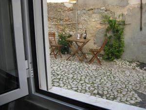 a view of a table and chairs from a window at The Back Yard Nest in Lisbon