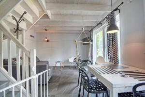 a dining room with a white table and chairs at Skandynawskie Domy in Pobierowo
