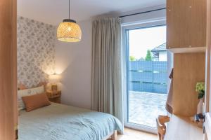 a bedroom with a bed and a large window at Apartament Vidok in Nowy Targ