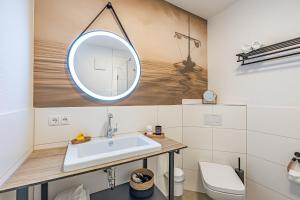 ein Badezimmer mit Waschbecken und Spiegel in der Unterkunft Deluxe Studio-Apartment "Wiking-Koje 10" direkt an der Schlei in Schleswig