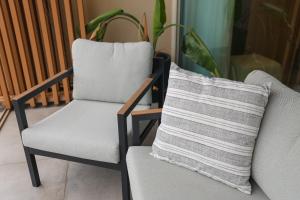 a pillow is sitting on a chair next to a chair at Green Coast Resort V94 in Palasë