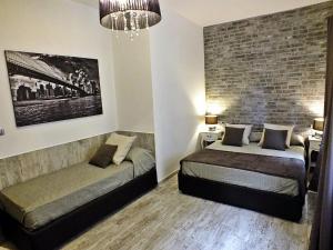 sypialnia z 2 łóżkami i ceglaną ścianą w obiekcie B&B Fiera Inn w Bolonii