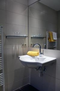 Baño blanco con lavabo y espejo en Appartements Zerzer en Ried im Oberinntal