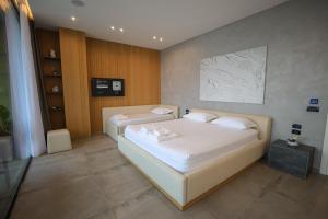 a bedroom with two beds with white sheets at Green Coast Resort V94 in Palasë