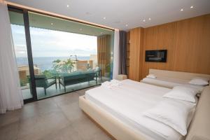 a bedroom with two beds and a large window at Green Coast Resort V94 in Palasë