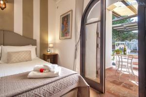 a bedroom with a bed with a stuffed animal on it at Restored Historic Mansion Paterno with Exclusive Pool, Wifi and AC for 20 people in Alghero +137 photos