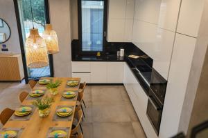 a kitchen with a long wooden table with chairs at Green Coast Resort V94 in Palasë