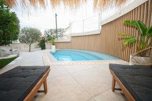 a swimming pool in the side of a building at Green Coast Resort V94 in Palasë