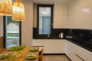 a kitchen with a table and a dining room at Green Coast Resort V94 in Palasë