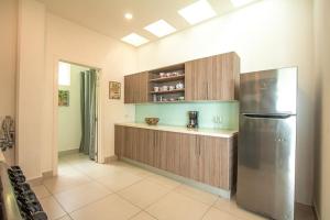 Una cocina con refrigerador y gabinetes de acero inoxidable. en Pacificdreams, en San Juan del Sur