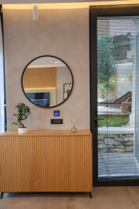 a mirror on a wall next to a wooden counter at Green Coast Resort V94 in Palasë