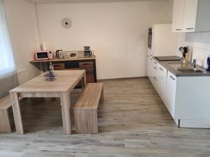 a small kitchen with a wooden table and a counter at Große Komfortable Monteurswohnung in Gutenacker