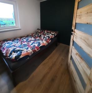 OsiekSiedlisko Radogoszcz, jacuzzi ,sauna的卧室里有一张床，床上铺着彩色的被子