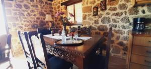 a kitchen with a wooden table and a stone wall at Νόστος in Ano Trikala