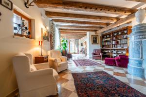 salon z białymi krzesłami i kamiennym filarem w obiekcie Hotel Relais Vecchio Maso w Trydencie