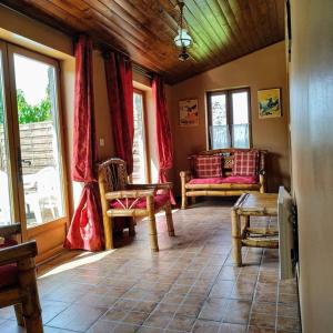 ein Wohnzimmer mit Sofa, Stühlen und Fenstern in der Unterkunft Charming Courtyard cottage 25kms Puy du Fou in Monsireigne