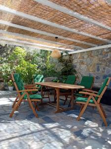 a wooden table and four chairs under a wooden ceiling at Mondo Piccolino in Samos